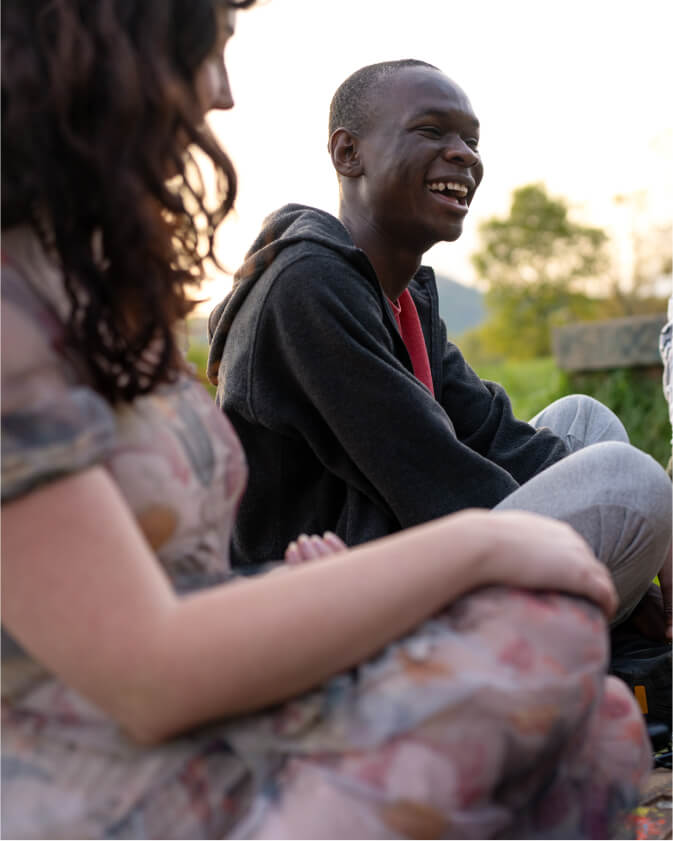 The student in focus is sitting outside with a group of friends.